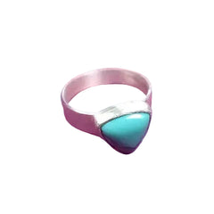 A silver ring featuring a triangular turquoise stone, displayed on a textured magenta-purple background.